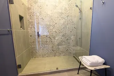 a bathroom with a shower with a towel on a chair at Lapazul Boutique Hotel in Savegre