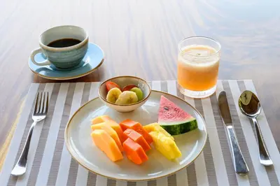a plate of fruit and a cup of coffee and a drink at Lapazul Boutique Hotel in Savegre