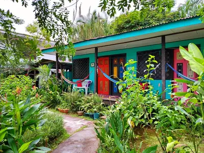 a house with colorful doors in a garden at Cabinas Tortuguero in Tortuguero