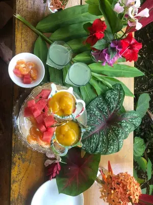 a table with a bowl of fruit and flowers at Cabinas Tortuguero in Tortuguero