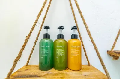 three green and yellow shampoo bottles on a shelf at Igloo Beach Lodge in Manuel Antonio