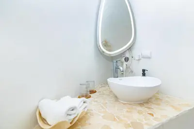 a bathroom with a sink and a mirror at Igloo Beach Lodge in Manuel Antonio