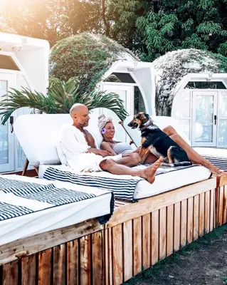 a man and a woman and a dog sitting on a couch at Igloo Beach Lodge in Manuel Antonio