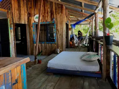 a bedroom with a bed and a hammock at Surfhost in Garza
