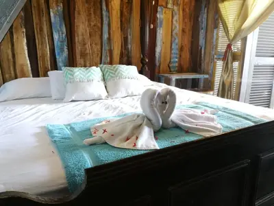 a bed with two swans towels sitting on it at Surfhost in Garza