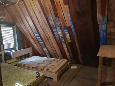 a bed in a room with a wooden wall at Surfhost in Garza
