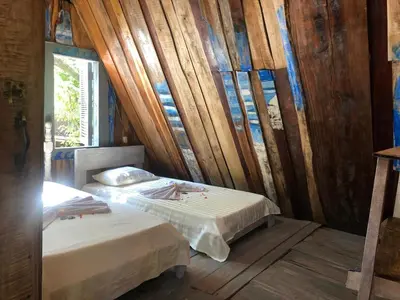 a bedroom with two beds in a room with wooden walls at Surfhost in Garza