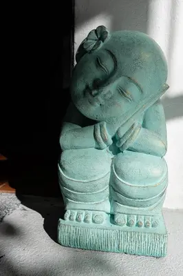 a statue of a child sleeping on a stack of rocks at SoulShine in Playa Avellana