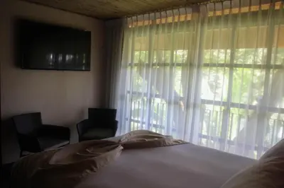 a bedroom with a bed and a window with curtains at Hotel Poza Blanca Lodge in San Mateo