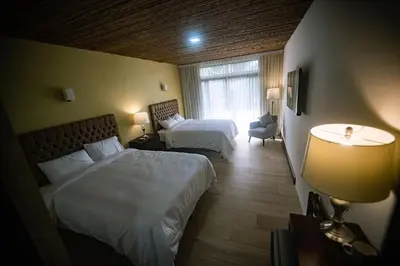 a hotel room with two beds and a window at Hotel Poza Blanca Lodge in San Mateo