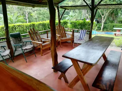a table and chairs sitting on a porch at Pochote Lodge in Hacienda Guayabo