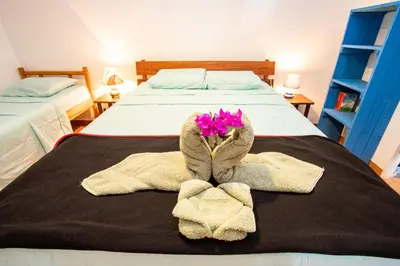 a bedroom with two beds with towels and flowers on the bed at Pochote Lodge in Hacienda Guayabo