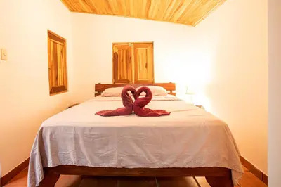 a bed with two towel animals on top of it at Pochote Lodge in Hacienda Guayabo