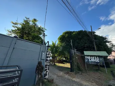 a fence with a sign on it next to a building at Yubarta Lodge in Uvita