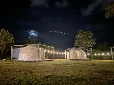 two tents in a field at night at Yubarta Lodge in Uvita