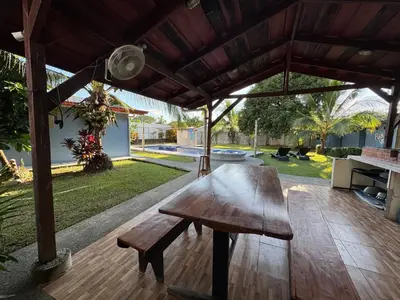 a wooden bench sitting on a wooden deck under a pavilion at Yubarta Lodge in Uvita