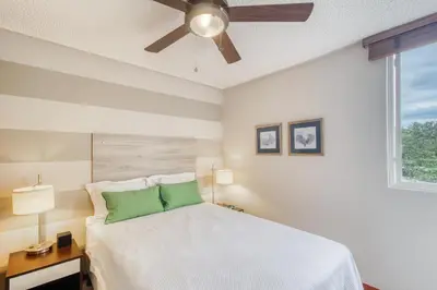 a bedroom with a white bed with a ceiling fan at Costa Linda 7-13 in Jacó