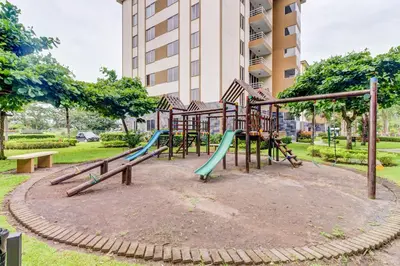 a playground in a park in front of a building at Costa Linda 7-13 in Jacó