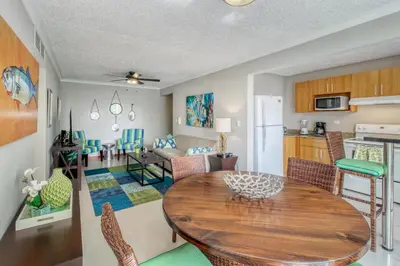 a kitchen and living room with a wooden table and chairs at Costa Linda 7-13 in Jacó