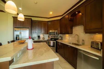 a kitchen with wooden cabinets and a counter top at AltaVista 5A 3 bdr Ocean View in Los Suenos in Herradura