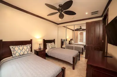 a bedroom with two beds and a ceiling fan at AltaVista 5A 3 bdr Ocean View in Los Suenos in Herradura