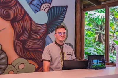 a man sitting at a table with a laptop at Lost Iguana Resort and Spa in Fortuna