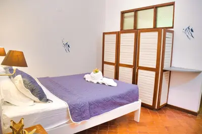 a bedroom with a bed with towels on it at Samara Pacific Lodge in Sámara