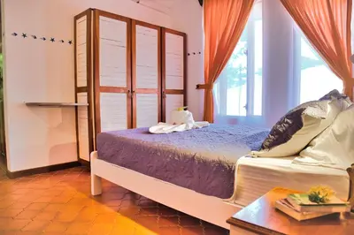 a bedroom with a bed and a window at Samara Pacific Lodge in Sámara