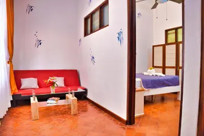a room with a red couch and a mirror at Samara Pacific Lodge in Sámara