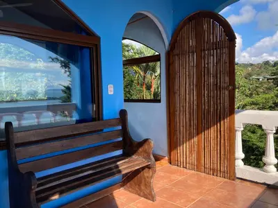 a wooden bench in a blue room with a door at El Paraiso Azul in Ojochal