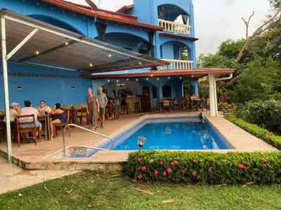 a swimming pool in front of a building with a restaurant at El Paraiso Azul in Ojochal