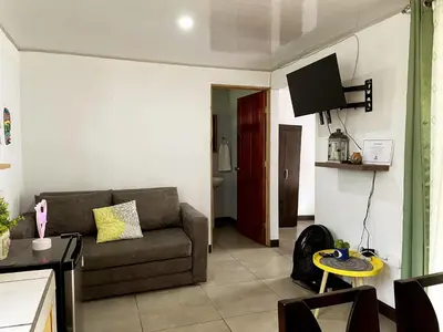 a living room with a couch and a tv at blanc haus in Grecia