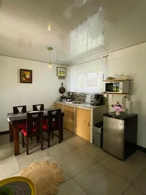 a kitchen with a table and chairs and a kitchen with a stove at blanc haus in Grecia