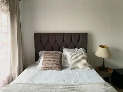 a bed with a headboard and two pillows on it at blanc haus in Grecia