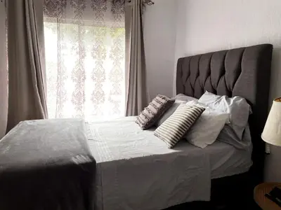 a bedroom with a bed with pillows and a window at blanc haus in Grecia