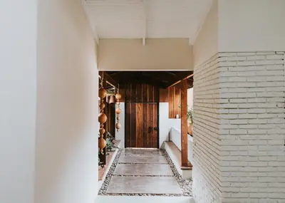 a white brick hallway with a wooden door at Casa 41 in Escazu