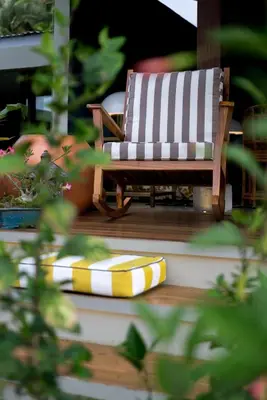 a wooden rocking chair on a porch with a cushion at Casa 41 in Escazu