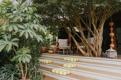 a row of yellow squares on a wooden deck with trees at Casa 41 in Escazu