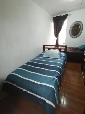 a bedroom with a bed with a blue and white striped blanket at Casa Kitus in San José