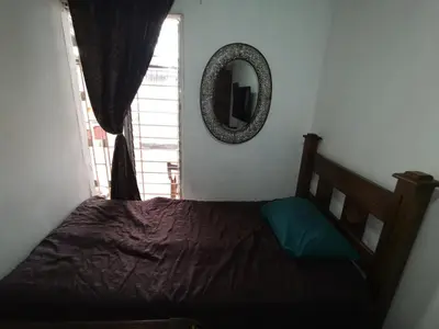 a bedroom with a bed with a mirror and a window at Casa Kitus in San José