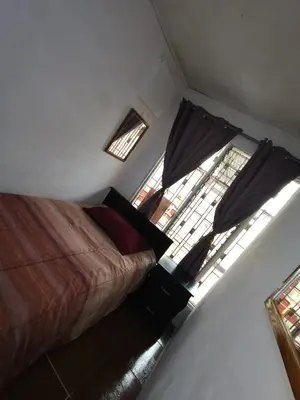 a bedroom with two beds and two windows at Casa Kitus in San José