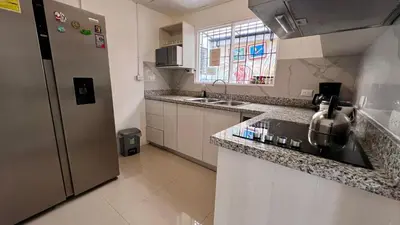 a kitchen with a sink and a refrigerator at Casa Kitus in San José