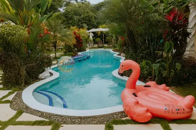 a swimming pool with a pink flamingo in the middle at COCO Beach Village in Matapalo