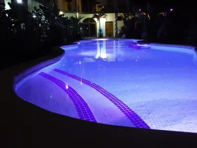 a large swimming pool lit up at night at COCO Beach Village in Matapalo