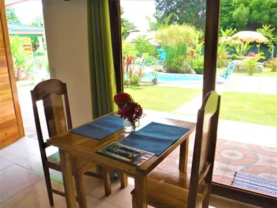 a dining room table and chairs with a view of a yard at COCO Beach Village in Matapalo