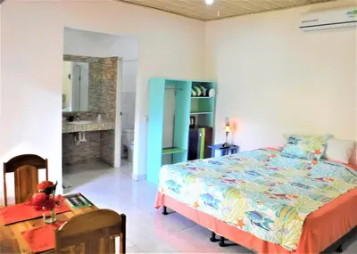 a bedroom with a bed and a table in a room at COCO Beach Village in Matapalo