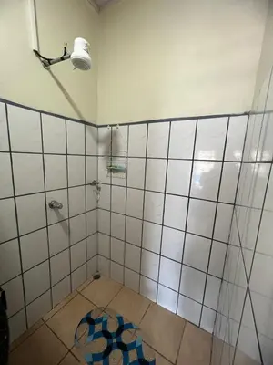 a bathroom with a shower with a blue rug on the floor at Los Sueños RyG 1 in Quepos
