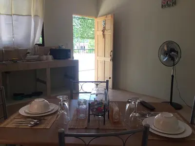 a dining room table with plates and glasses and a fan at Los Sueños RyG 1 in Quepos