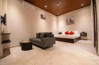 a bedroom with a bed and a couch and a chair at Surfside Apartments - Playa Carmen in Santa Teresa Beach