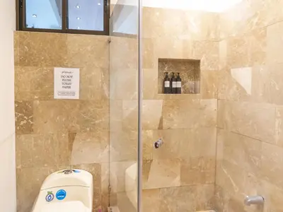 a bathroom with a shower with a glass door at Surfside Apartments - Playa Carmen in Santa Teresa Beach